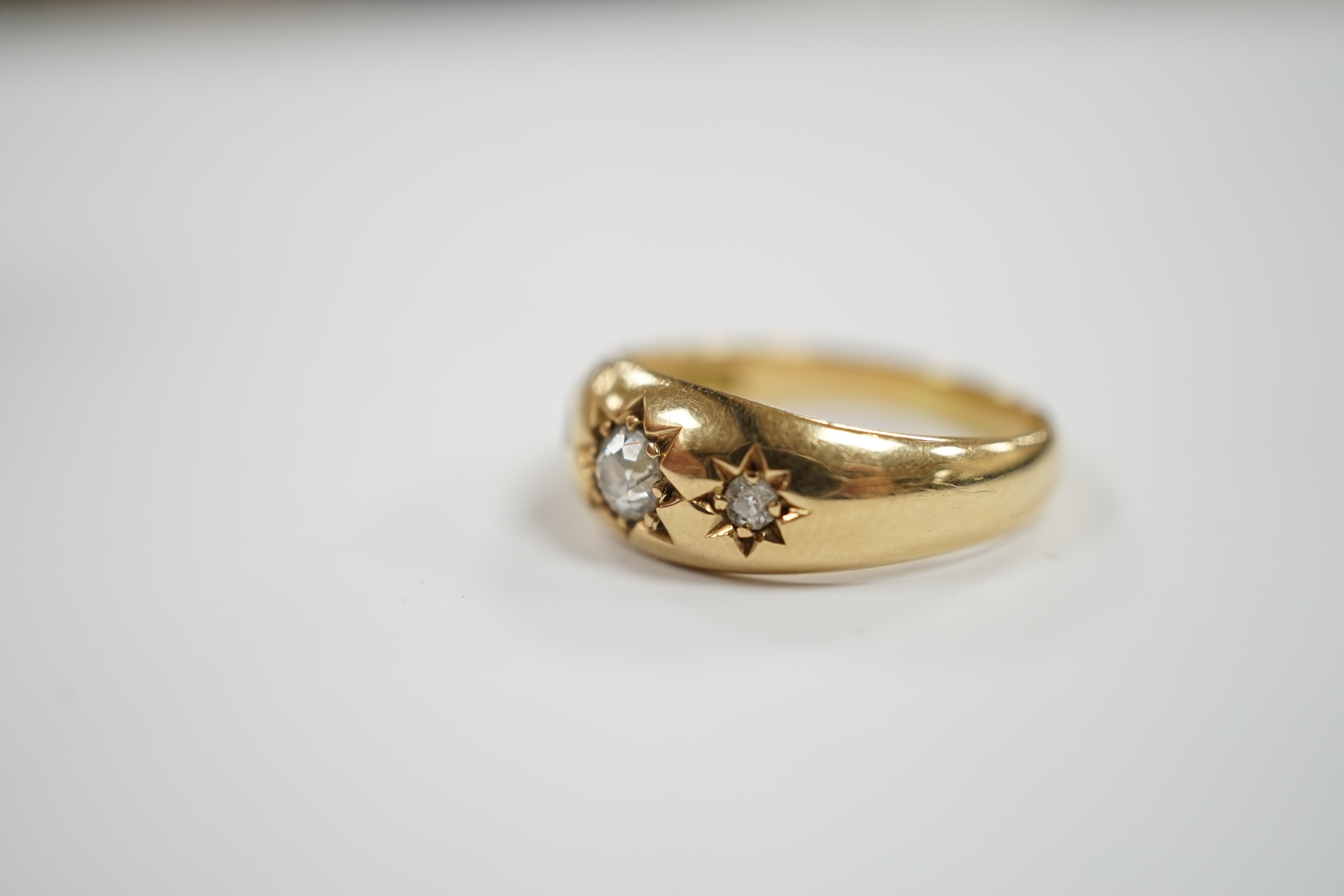 An Edwardian 18ct gold and gypsy set three stone diamond ring, size Q, gross weight 6.3 grams.